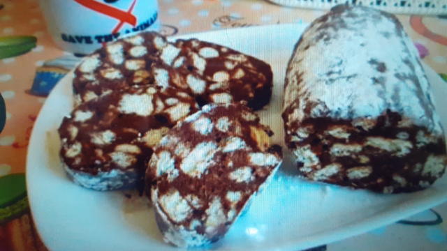 е да се прибави и 1с.л алкохол коняк или ром когато се разтопи маслотокаъо се разбърка с телесна бъркалка се сваля и оставяме леко да се охлади сипваме натрошени бисквити и се разбърква внимателно с лъжица да не станат на каша засилва се с парче прозрачно фолио сипваме бисквитената смес и се оформя като сладък салам завива се на бисквитено роло с колкото и се връзва като бонбон отгоре с хартия и 2 часа в хладилника или 1ч