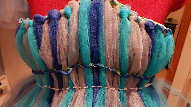 lstreifen nacheinander an die Corsage knoten. Und dann durch ein unteres Loch der Corsage durchziehen, sodass ein Streifen nach dem anderen entsteht.